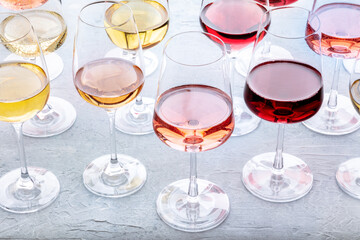 Wine glasses at a tasting. Rose, red, and white wine, drinks on a table at a winery. An assortment of wines of many different colours