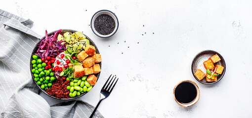 Healthy vegan food. Buddha bowl with quinoa, fried tofu, avocado, edamame, green peas, radish,...