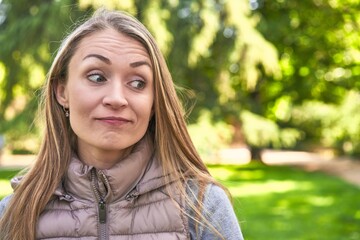 Middle-aged woman in a park on a sunny day happy, smiling and cheerful.