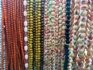 Religious beads with colorful strings. Muslim prayer chaplet market close up shot. Colorful plastic rosaries in the market. Beautiful Muslim prayer beads close up view. Islamic rosary market.