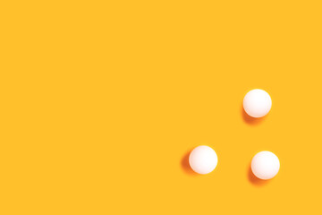 Ping pong balls on a yellow background. Minimal composition with copy space. - obrazy, fototapety, plakaty