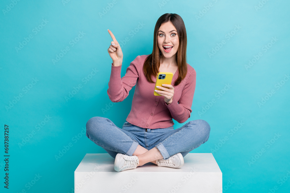 Canvas Prints Full length photo of excited woman trendy shirt directing at eshop hold smartphone sit on platform isolated on teal color background