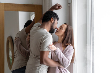 Multiethnic American couple embracing at home.