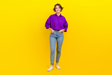 Fototapeta premium Full body photo of cheerful businesswoman wear violet shirt denim jeans posing for magazine formal clothes isolated on yellow background