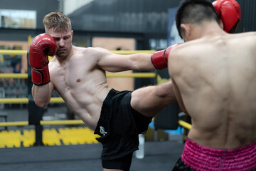 Two male athlete boxing competition in ring. Diverse ethnic men kick fighting in kickboxing...