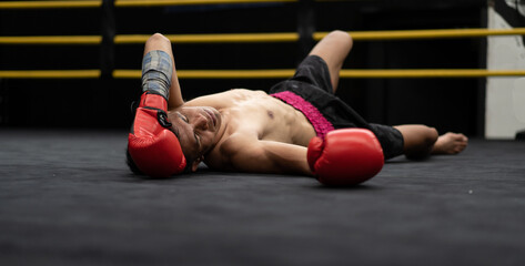 Unconscious Asian boxer lay on floor referee counting down knockout in the ring at fitness gym. Boxing is fighter sport training need body muscular strength, power fist and sweating to become champion - Powered by Adobe