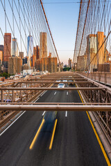 Fototapeta na wymiar Moving cars on the Brooklyn Bridge in the New York City in the morning dawn.