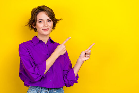 Photo of cute lady agent direct fingers empty space useful information wear violet office blouse isolated yellow color background