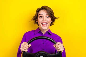 Photo of positive astonished lady hands hold wheel open mouth isolated on yellow color background