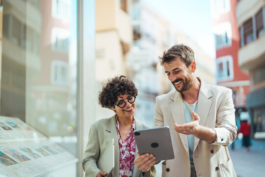 Business People Discussing And Smiling While Walking Together Outdoor. Two Business Colleagues Having Discussion Whilst Walking Outside Office. Business People Dressed In Formal Wear Meeting 