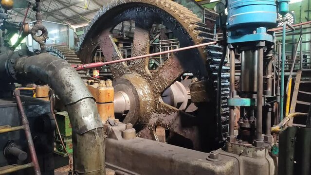 4k video of Steam engine powering sugar cane milling in a sugar factory.