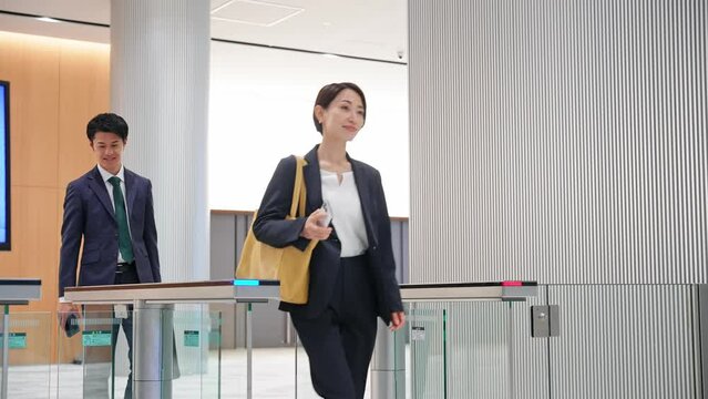 エントランスゲートを通るビジネスパーソン
