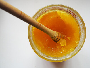 Crystallized honey in a glass jar. Focused in solidified honey.