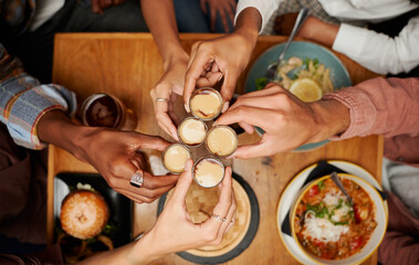 Close-up of young multiracial group of friends in casual clothing doing toast with drinks at restaurant