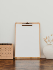 Wooden clipboard with blank paper with copy space on white background with decoration.