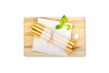 Grissini or salted breadsticks on a wooden board isolated on a white background. Fresh Italian appetizer. Italian bread.