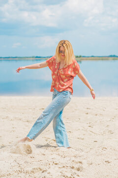 Woman in colorful cotton fashionable shirt and flared jeans. Trendy clothes, vacation concept. Style 70s