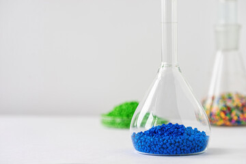 Plastic factory laboratory. Glass flasks with colored dye in granules for plastics. polymer...