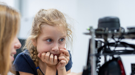 girl female teen children concentrate look Machine Learning Robot is Moving Under Control robot...