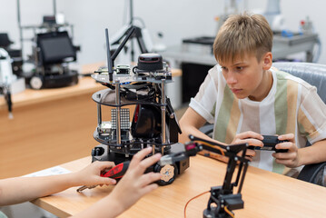 Fototapeta na wymiar Group Kid teen child enjoy Machine Learning Robot arm is Moving Under coding Control robot at stem technology class, stem education for digital automation learn for use artificial intelligence ai