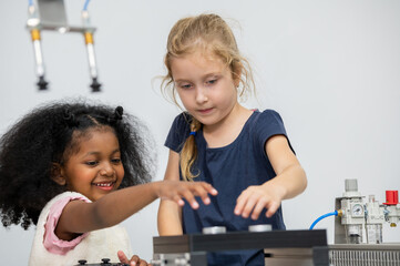 Kid female teen child enjoy Machine Learning Robot arm is Moving Under Control robot at technology...