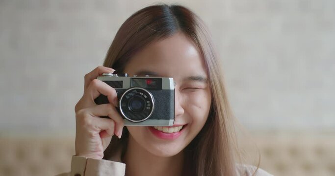 Portrait of Attractive beautiful asian stylish female photographer in good mood with camera smiling, looking with confident and happy emotion. Lifestyle, hobby and occupation. close up face headshot.