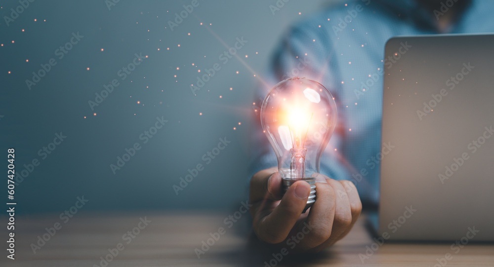 Poster hand holding the glowing lightbulb that is illuminating for creative thinking idea of problem solvin