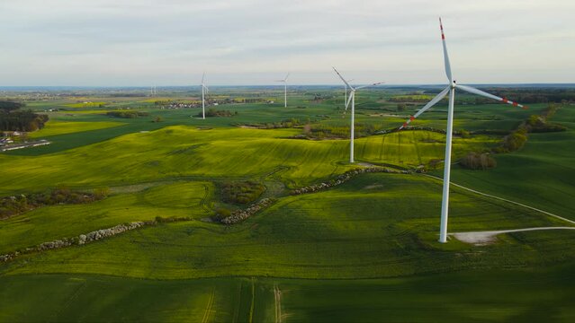 Windmill generator large wind turbines with blades in field with growing crops. Electricity, ecological saving and alternative power source