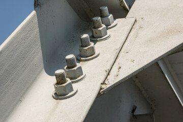 Bolts and nuts on metal plates of steel structure of heavy duty straight crossbar of frame and...