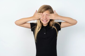 beautiful teen girl wearing black dress over white studio background covering eyes with hands smiling cheerful and funny. Blind concept.