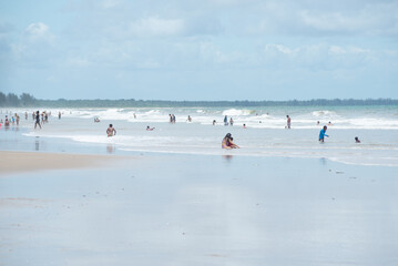 Fototapeta na wymiar People bathing in the sea and walking on Guaibim beach in the tourist town of Valenca, Bahia.