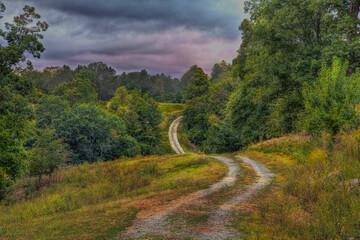 Curvy Dirt road in the Country winding through the hills of Missouri 