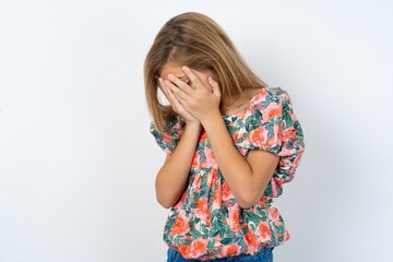 Sad beautiful teen girl wearing flowered dress over white studio desperate and depressed with tears on her eyes suffering pain and depression  in sadness facial expression and emotion concept