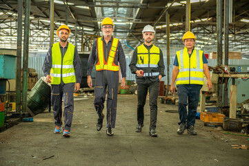 Group of engineer foreman walk line of troops straight in and talk together at end time of work in old Factory. unity teamwork colleague foreman and trainee walk straight in and talk collaboration.