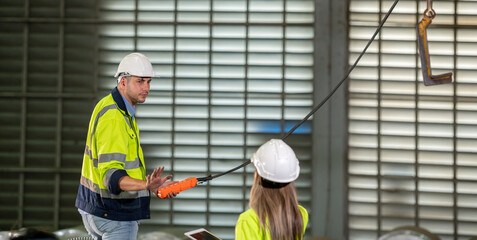Factory apprenticeship. Woman mentor teaching man employee trainee operating machine look monitors and hand press control button process machinery. Leader foreman explaining engineer control machine