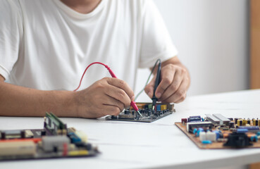 Fototapeta na wymiar Technician using a soldering iron to repair a circuit board