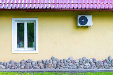 outdoor air conditioning unit on the wall of the house
