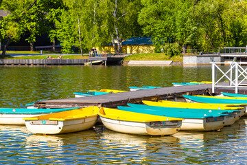 boats of different colors stand on the pier.