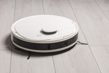 A robot vacuum cleaner at home on the floor.Helper at home. Lifestyle.	
