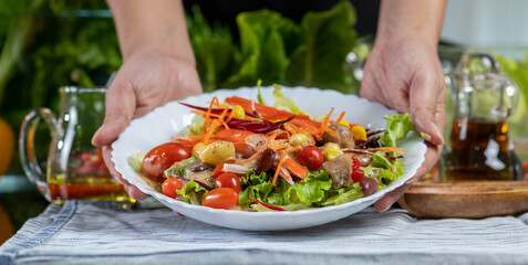 woman chef show mix fresh green baby cos salad and pour salad dressing in glass blow. Organic Vegetables mix all green salad In glass bowl. Breakfast fresh salad and clean vegetable panorama 
