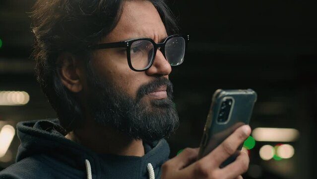 Sad Muslim man reading message in mobile phone upset bad news confused puzzled pensive Arabian guy in glasses problem with smartphone notification Indian user think cellphone difficulties at parking