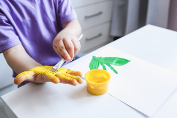 Children's art workshop, the child makes a handprint with paints
