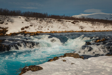 Fototapeta na wymiar Bruarfoss waterfall and its surroundings captured on a winter afternoon in Iceland.