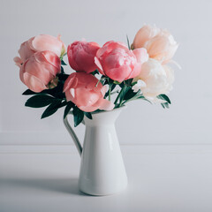 Beautiful bouquet of fresh coral peony flowers in full bloom in vase. Floral still life with blooming peonies.