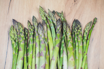 Green fresh bunch of a asparagus on wooden background. Healthy diet food. Vegetarian food.