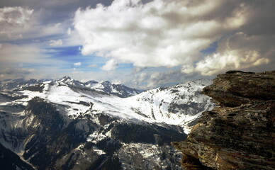 querformat, schneebedeckte berge, massive wolkenbank, blauer himmel, gebirgskette, bad hofgastein, vordergrund granitfelsen, österreich