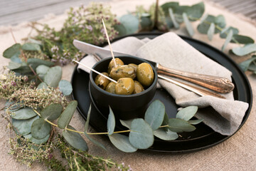Mediterranean table setting with olives, decorated in natural boho style. Background concept for...
