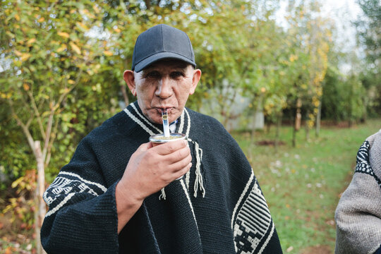 Calm senior man drinking hot beverage in park