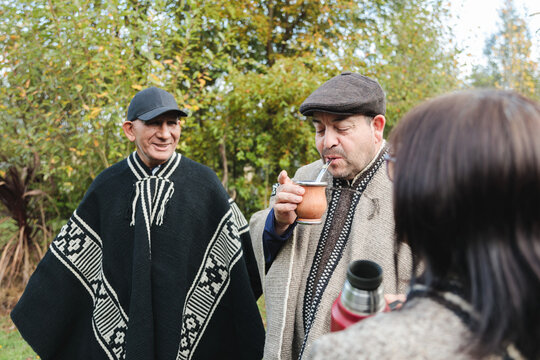 Smiling senior friends with drinks in park together