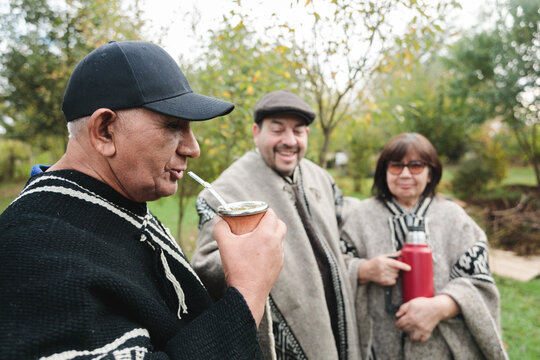 Smiling senior friends with drinks in park together